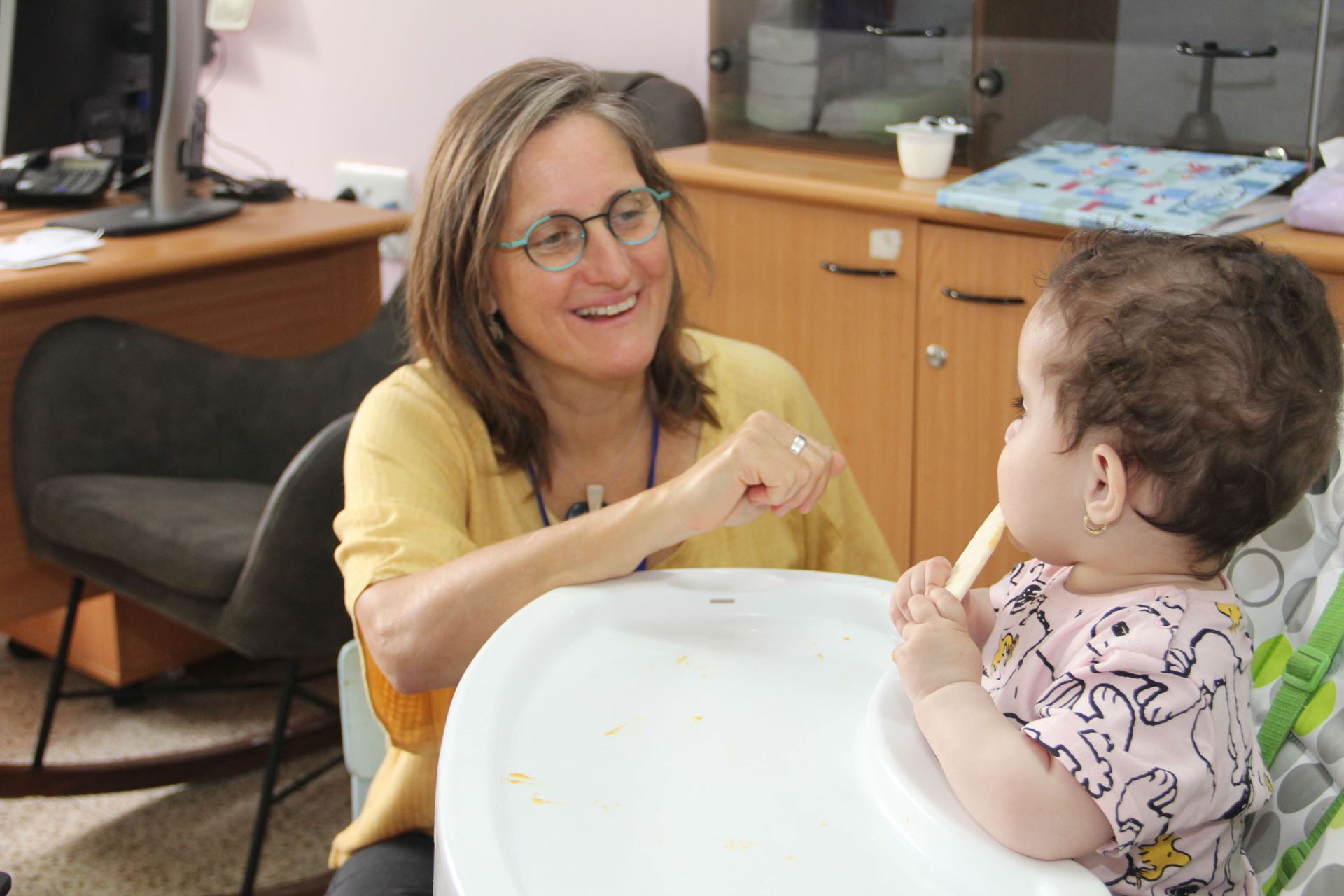 מטפלת מקצועית במרכז שיקום ילדים מסייעת לתינוק עם הפרעות אכילה